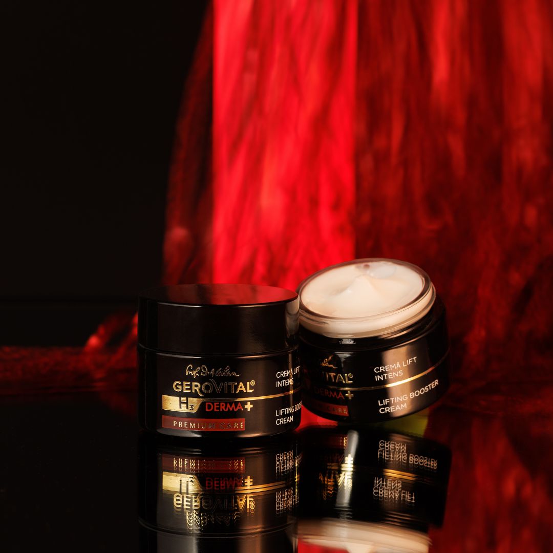 Due vasi neri, uno aperto. Scritta: Gerovital H3 Derma+, Premium Care, Crema Lift Intens, Lifting Booster Cream. Sfondo riflettente.