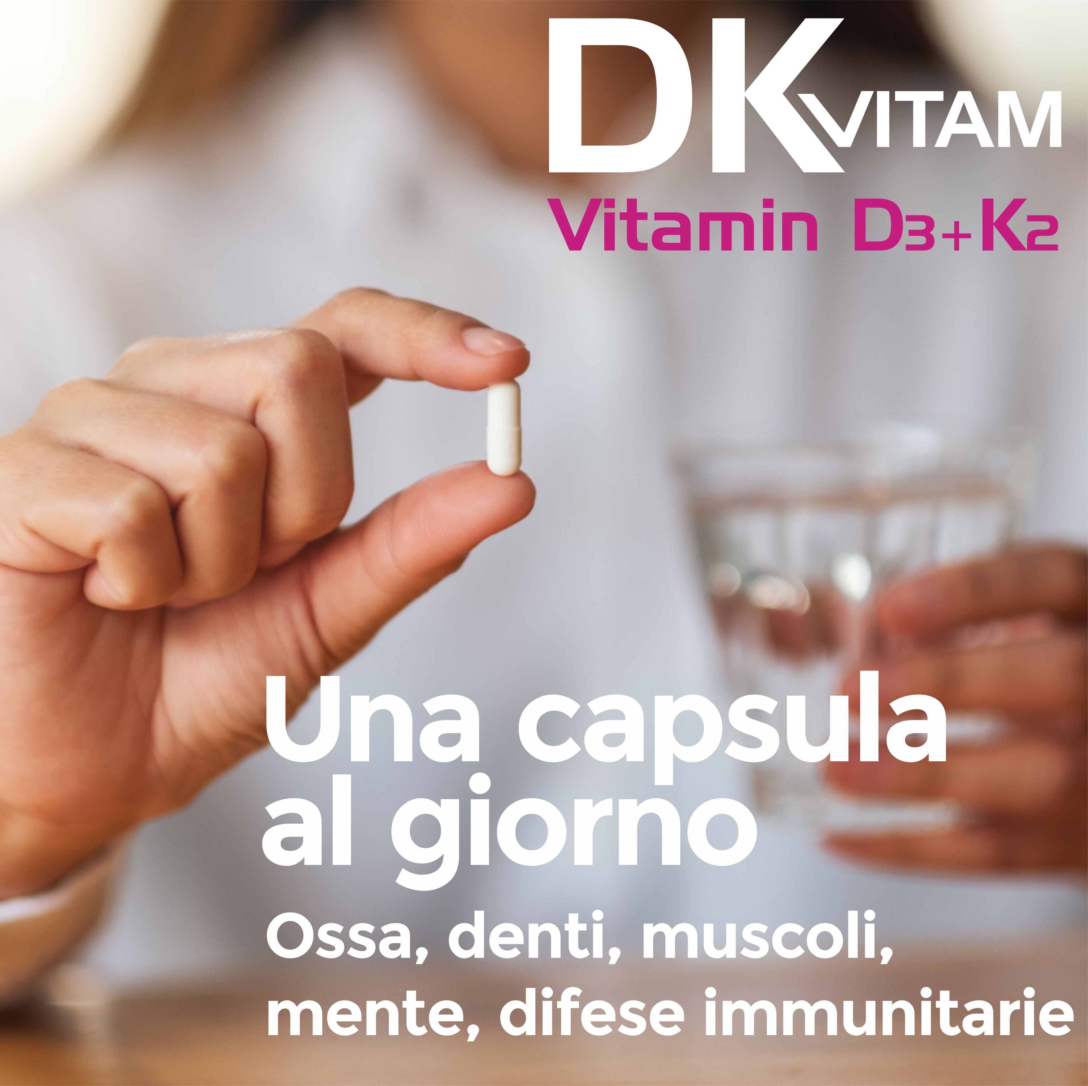 Mano che tiene una capsula Vitamina D3+K2 davanti a un bicchiere d'acqua.