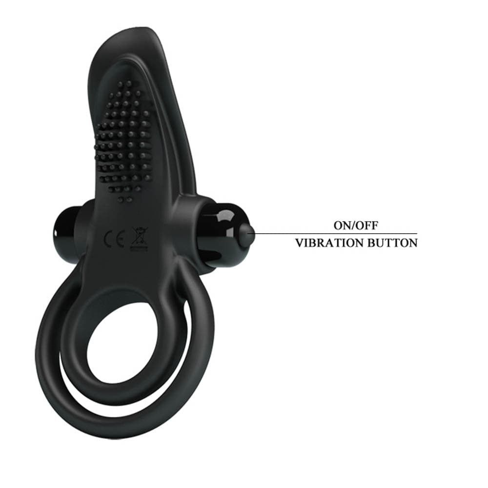 Anello penieno nero con due anelli e stimolatore. Testo 'ON/OFF VIBRATION BUTTON'.