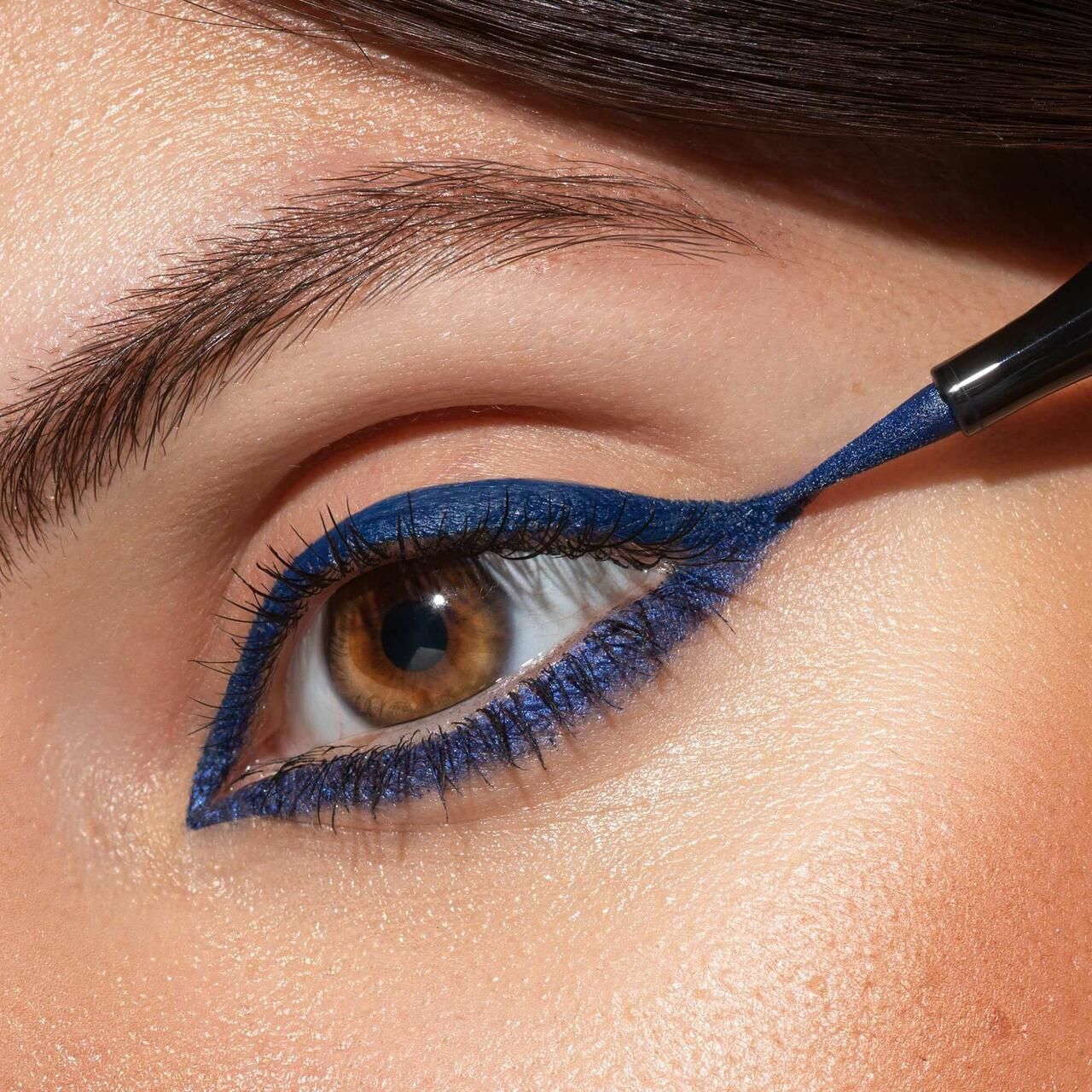 Occhio con eyeliner blu. L'eyeliner viene applicato sulla palpebra superiore per formare una linea.