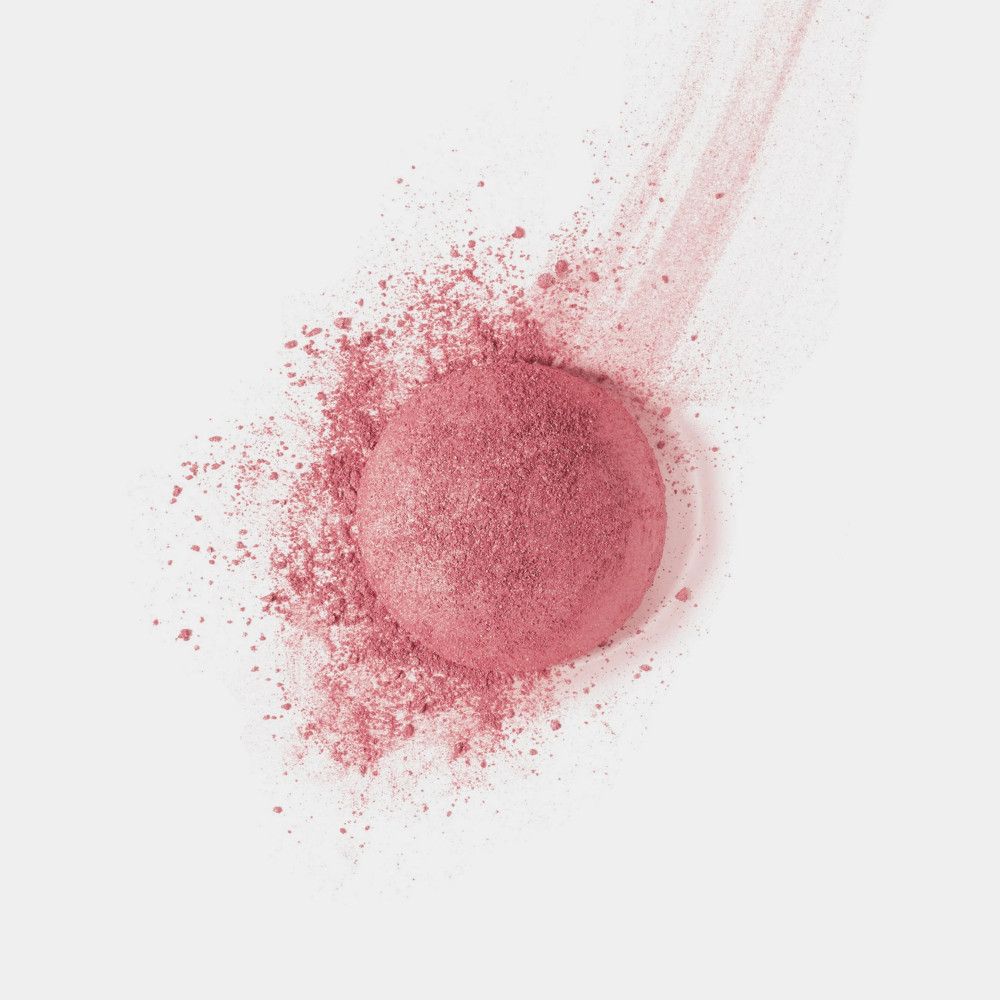 Fard rosa parzialmente disperso. Nuvola e traccia di polvere su sfondo bianco.