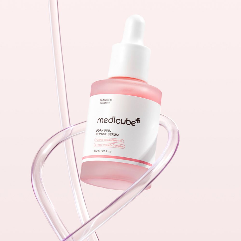 Flacone di Medicube PDRN Pink Peptide Serum con contagocce, circondato da tubi trasparenti.