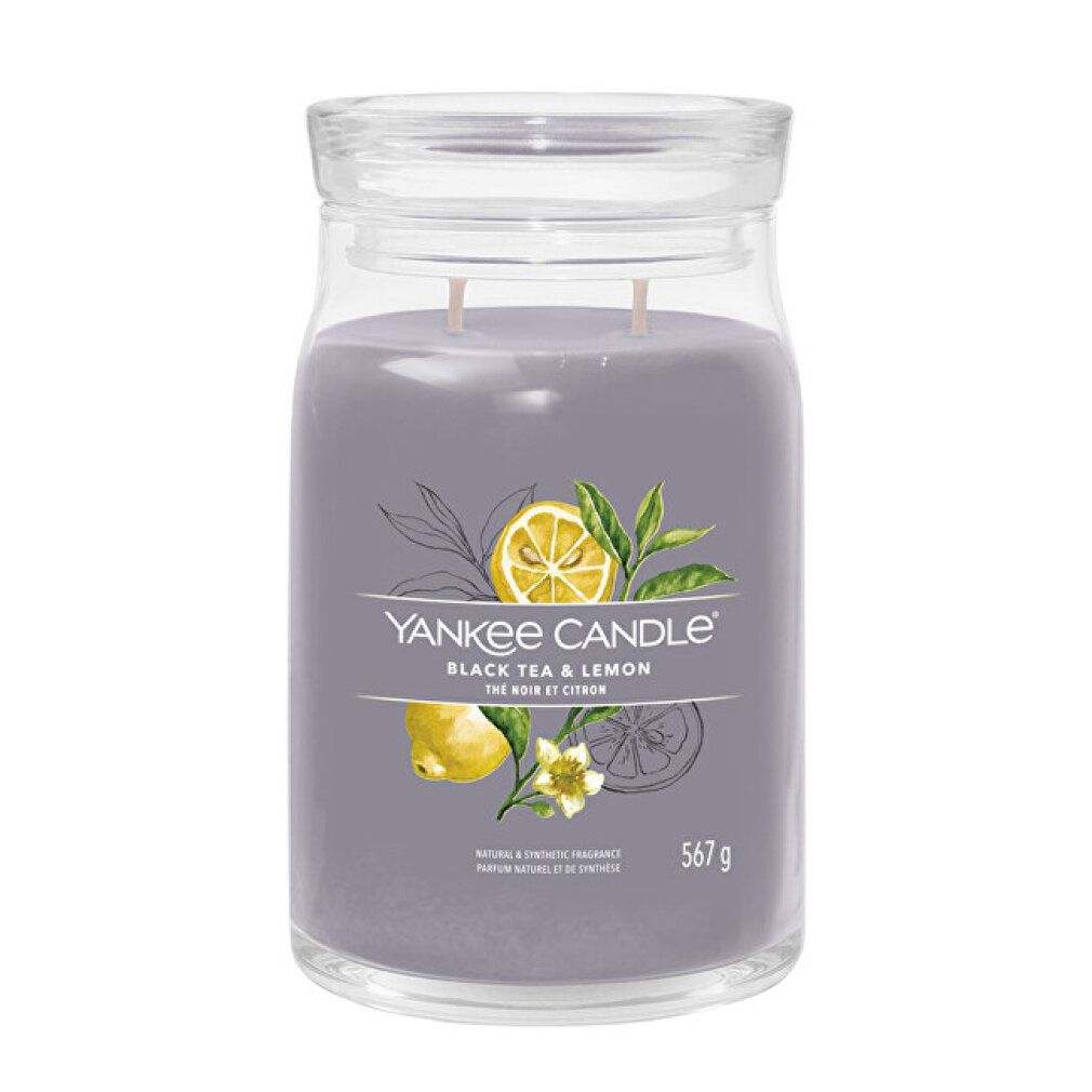Candela grigia in vetro con coperchio. Scritta: Black Tea & Lemon. Illustrazioni di limone e foglie. Peso: 567 g.