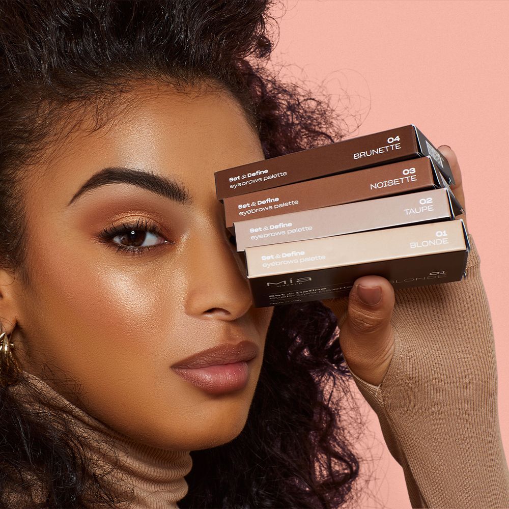 Donna tiene quattro palette sopracciglia Mia Makeup. Etichette colore: Blonde, Taupe, Noisette, Brunette.