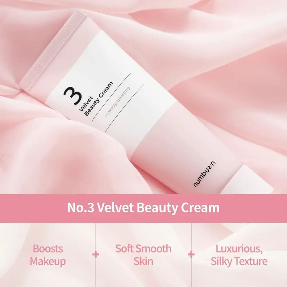 Tubo di crema rosa e bianco. Scritta: No.3 Velvet Beauty Cream. Marchio: numbuz:n. Su tessuto rosa.