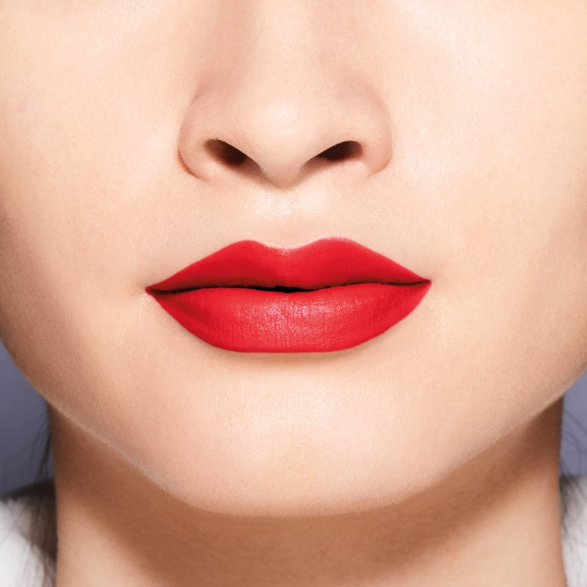 Primo piano di labbra con rossetto rosso. Texture opaca, applicazione uniforme.