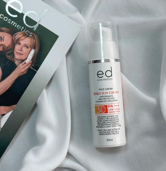 Flacone di crema solare accanto a una rivista. Scritta: ED cosmetics, Face Cream, Daily Sun Cream, SPF 30, PA+++.