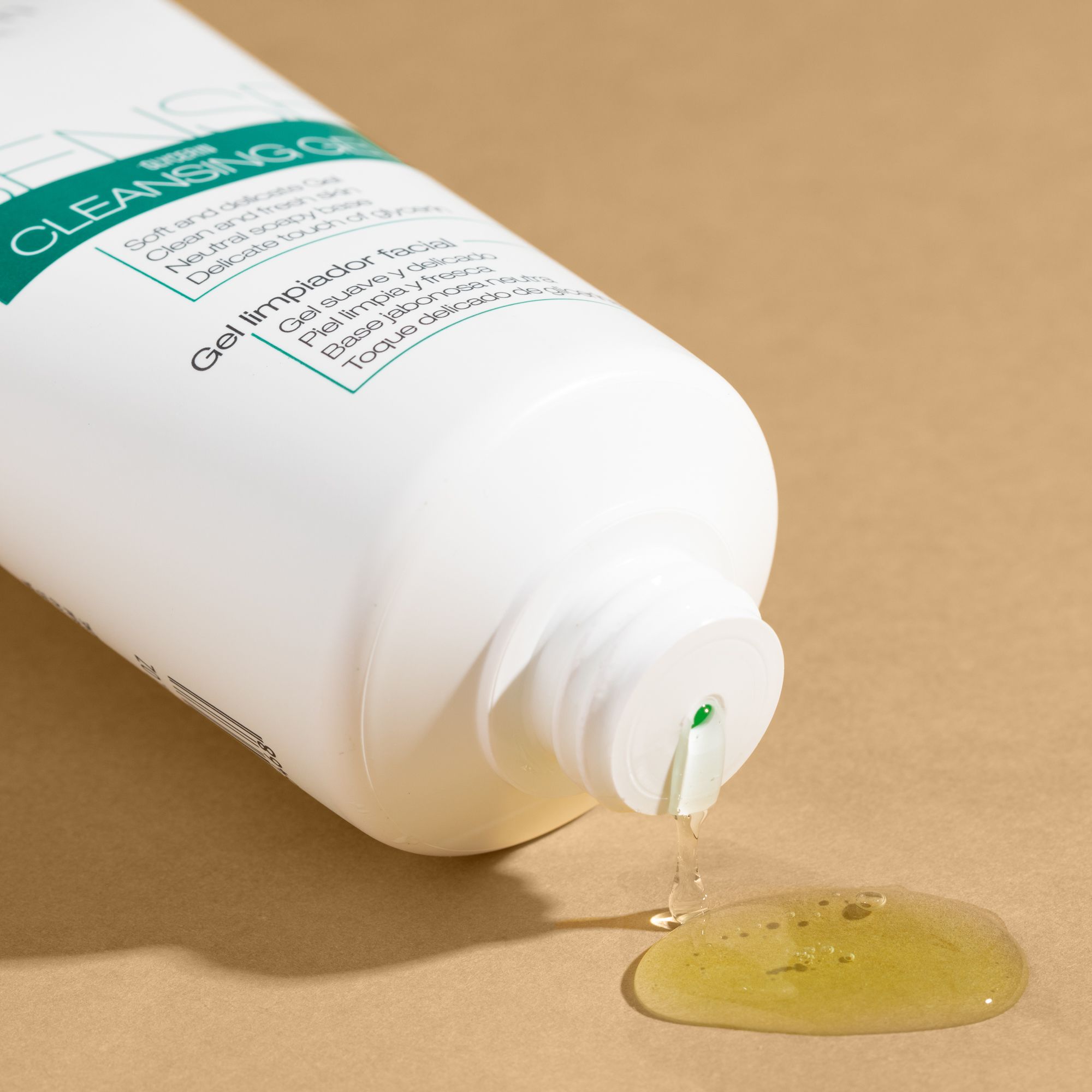 Tubo bianco da cui fuoriesce un liquido gelatinoso. Scritta: Sense Cleansing Gel. Sfondo: beige.