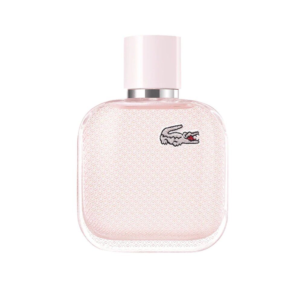 Flacone rosa con tappo rosa chiaro. Logo coccodrillo Lacoste. Forma quadrata. Su sfondo bianco.