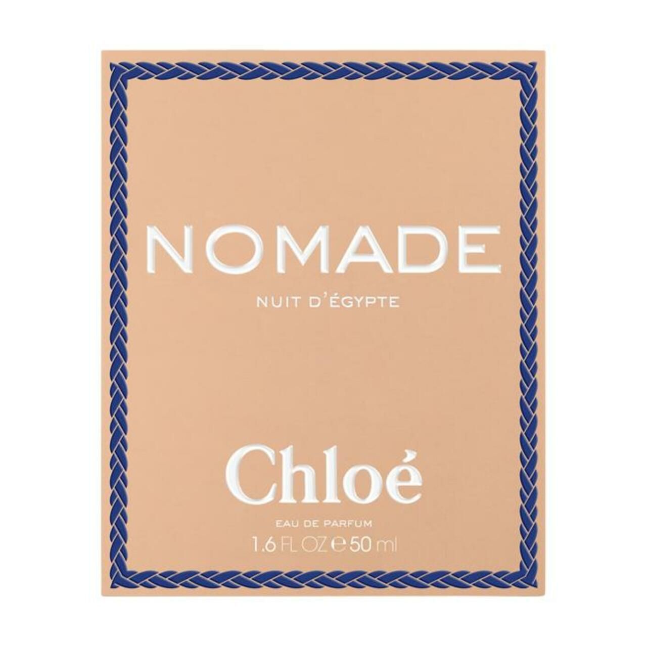 Confezione con nome del prodotto e logo. Lo sfondo è beige con una cornice blu intrecciata. Testo: Nomade Nuit d'Egypte, Chloé.