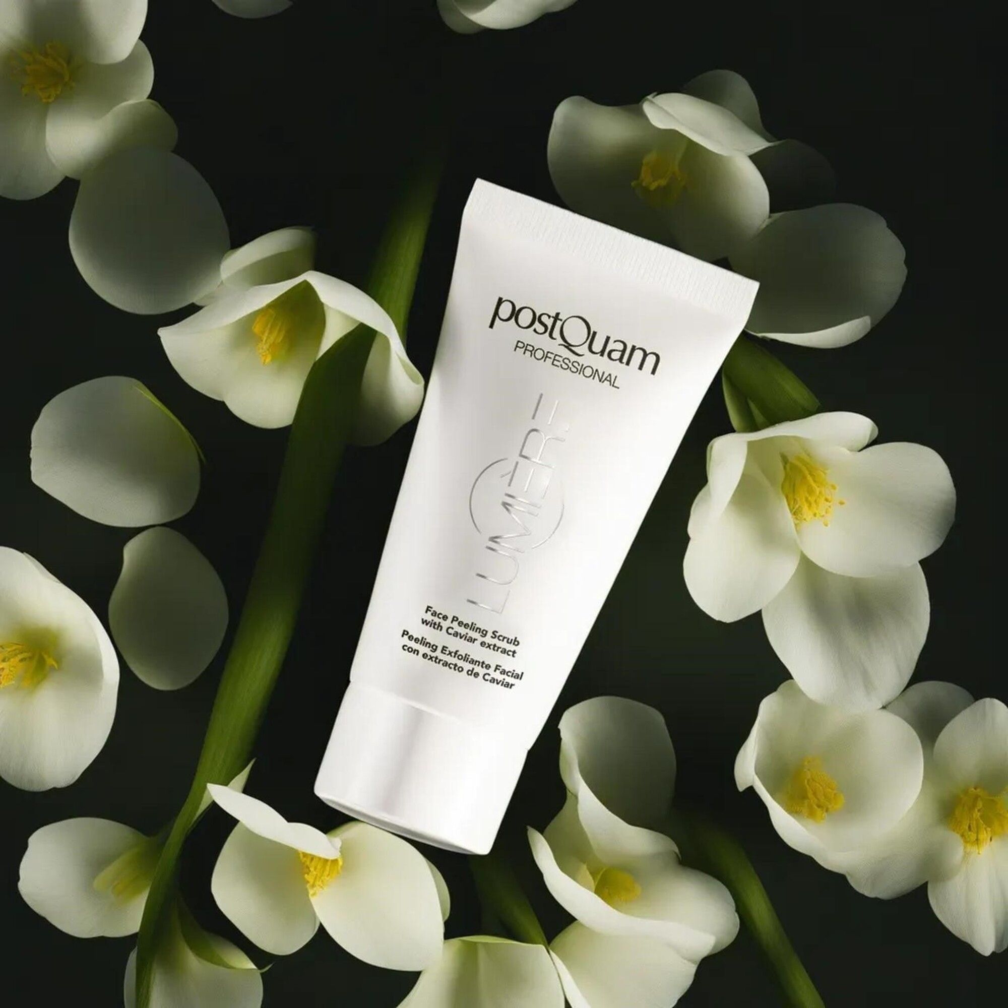 Tubo bianco con nome e testo del prodotto. Circondato da fiori bianchi su sfondo scuro. Testo: Face Peeling Scrub with Caviar extract.
