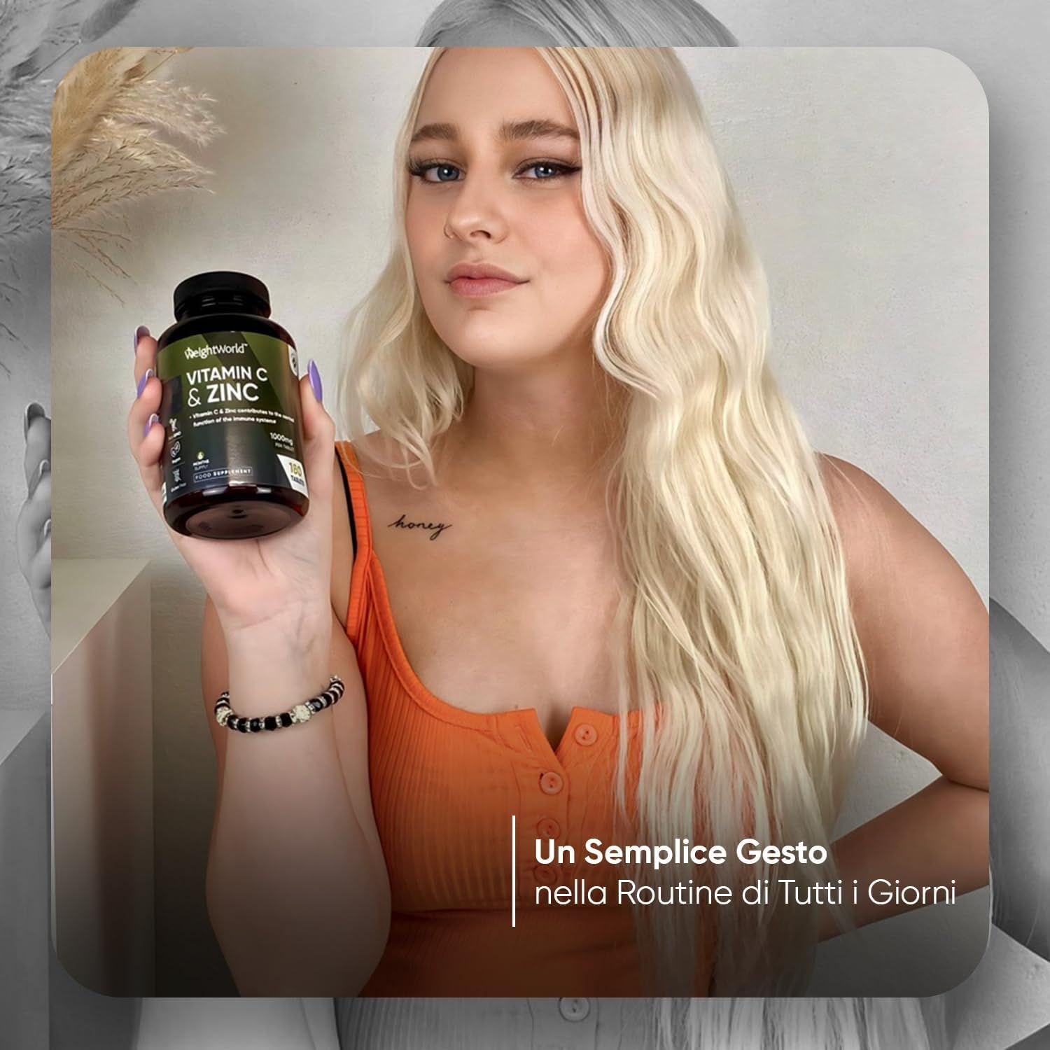 Donna che tiene in mano un flacone di Vitamina C & Zinco. Testo: Un semplice gesto nella routine quotidiana. Donna con tatuaggio e braccialetto.