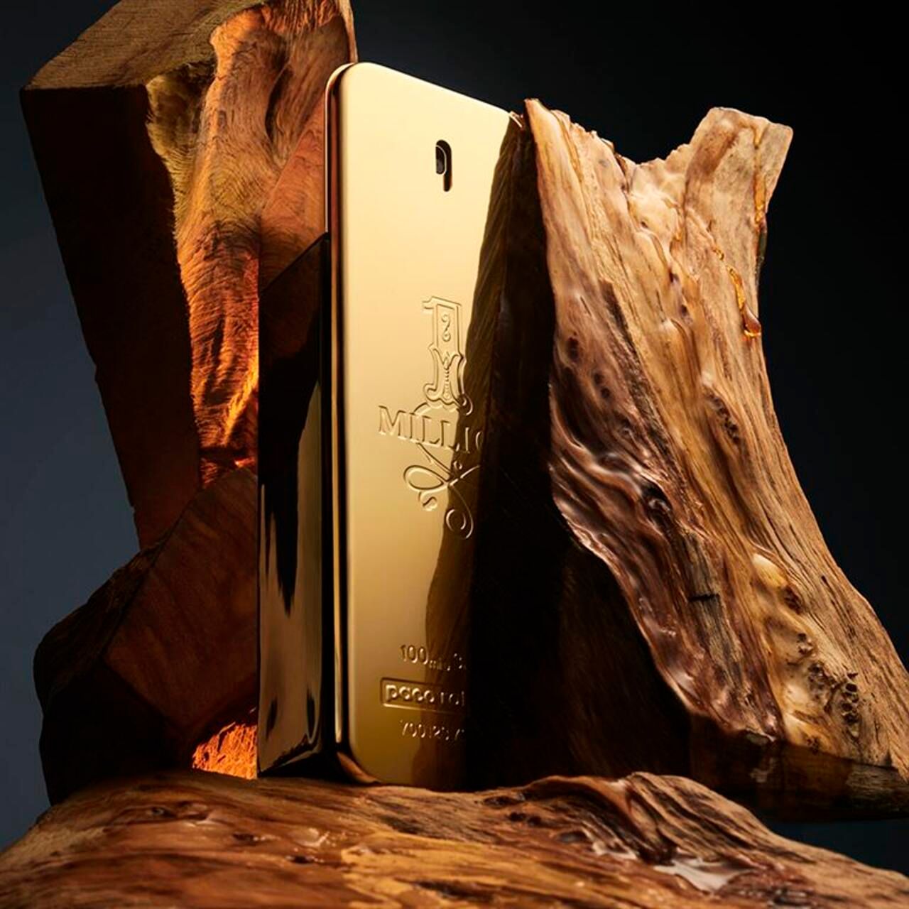 Flacone dorato "1 Million" davanti a pezzi di legno. Erogatore nero. "paco rabanne" in basso.