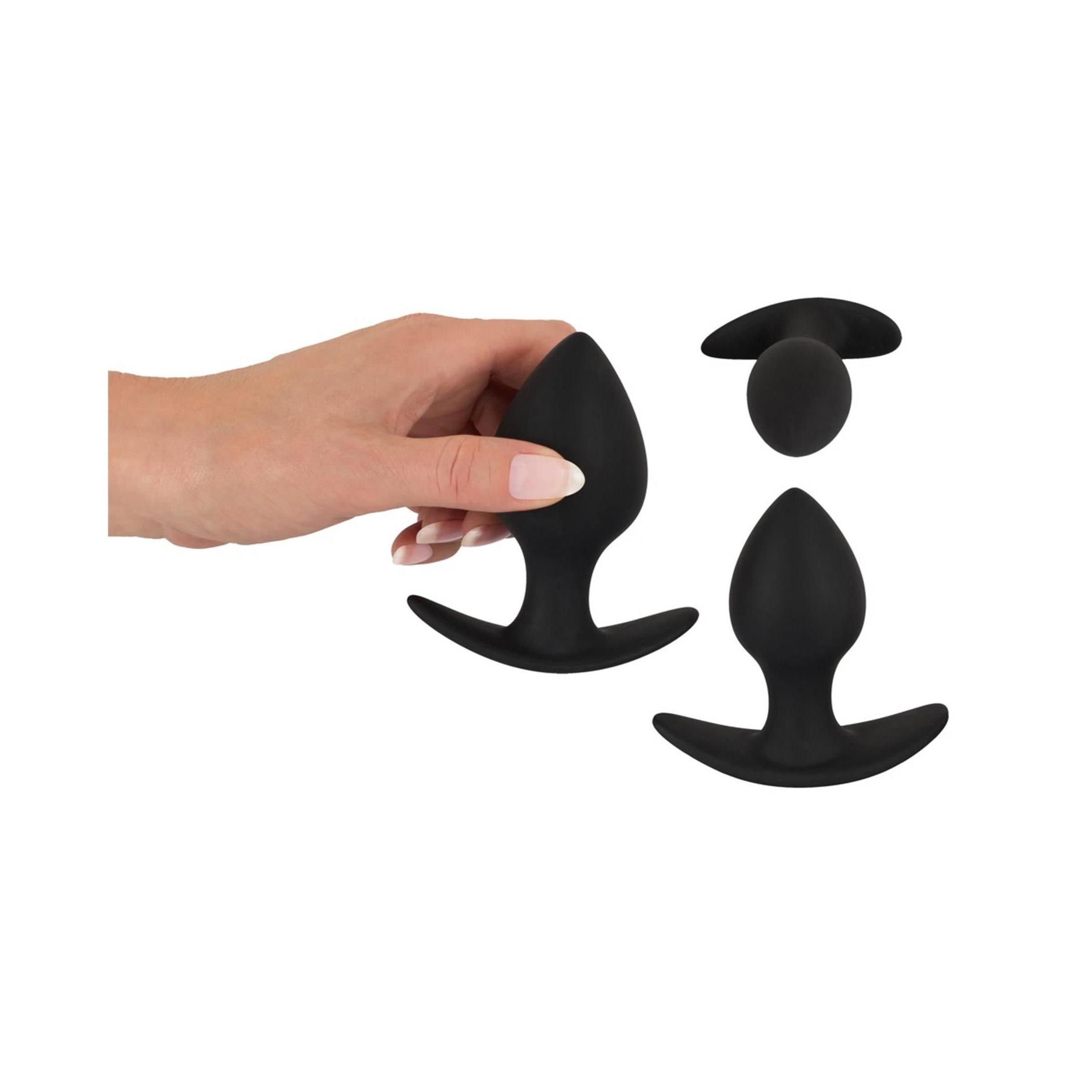 Mano che tiene due dilatatori anali neri. Punta conica, base curva. Diverse dimensioni.