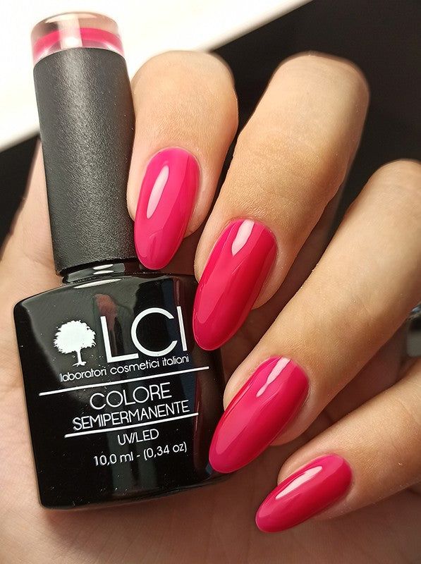 Mano con unghie fucsia smaltate, accanto flacone smalto. Scritta: LCI, Colore Semipermanente, UV/LED.