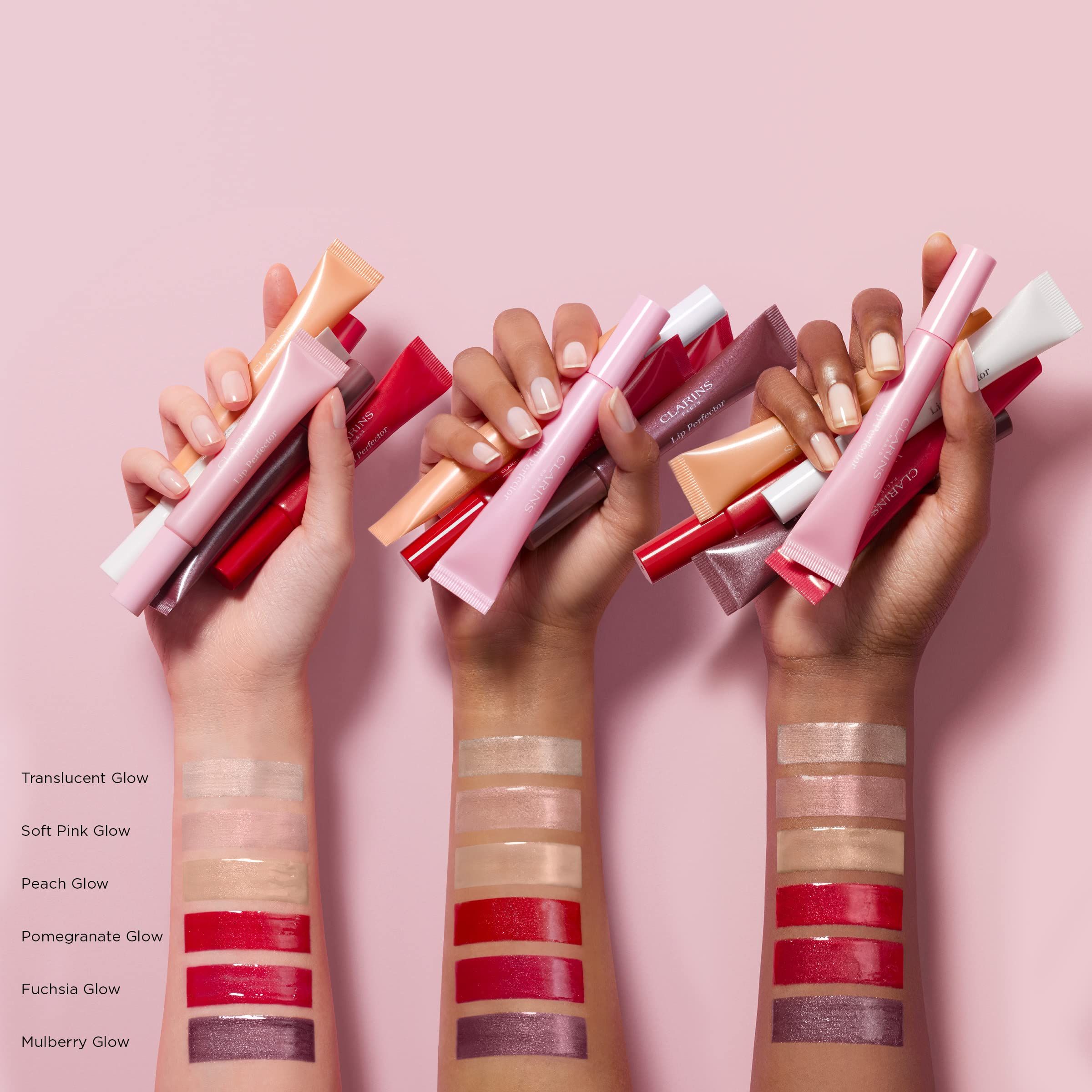 Mani che tengono tubetti di lucidalabbra. Diversi colori applicati sulle braccia.