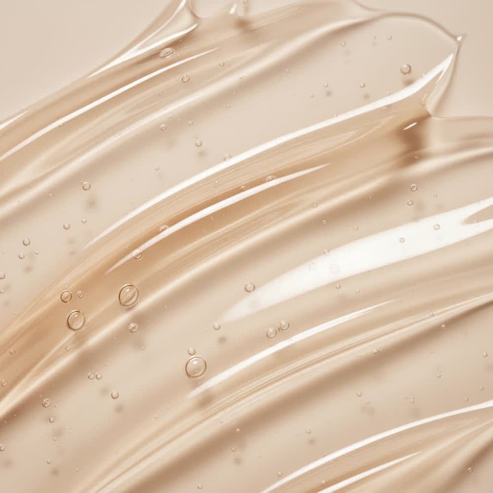 Primo piano di gel trasparente. Il gel è applicato in strisce ondulate. Sono visibili alcune bolle d'aria.