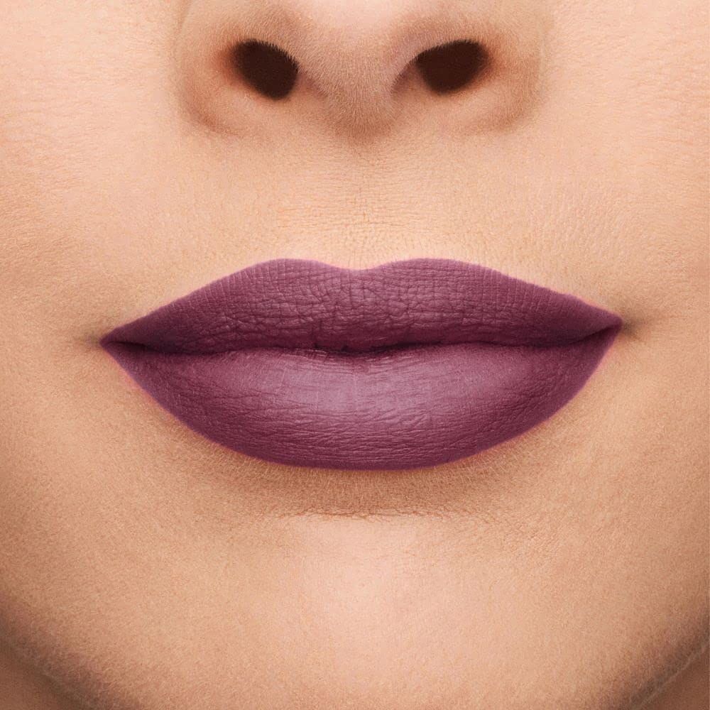 Primo piano di labbra coperte da rossetto rosso scuro. Tono della pelle.