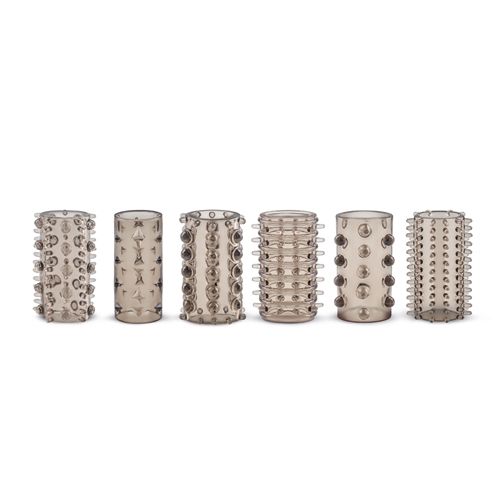 Sei rivestimenti penieni in silicone trasparente con borchie, in diversi modelli. Disposti su sfondo bianco.