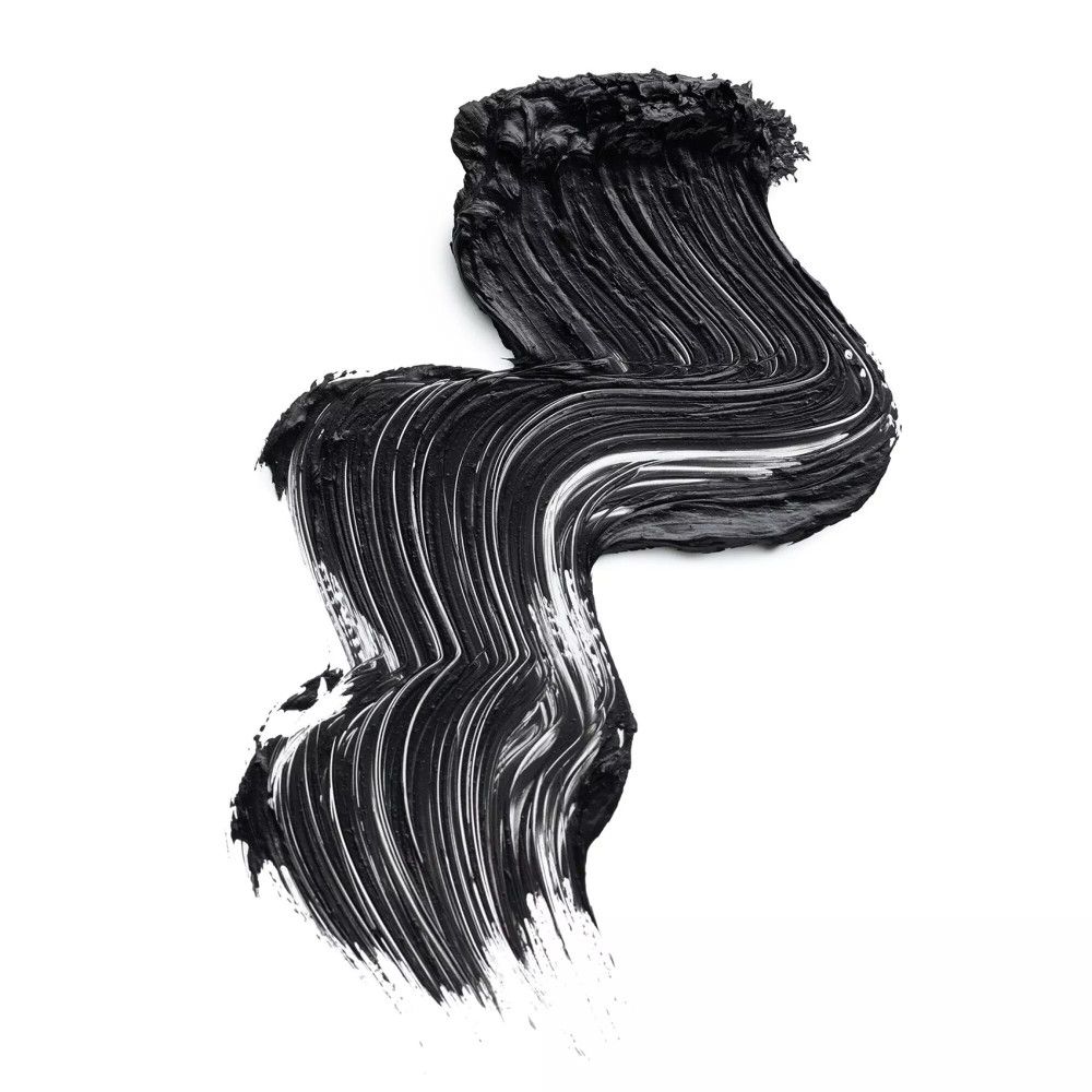 Striscio di mascara nero su sfondo bianco. Applicazione a forma di onda. Texture visibile.
