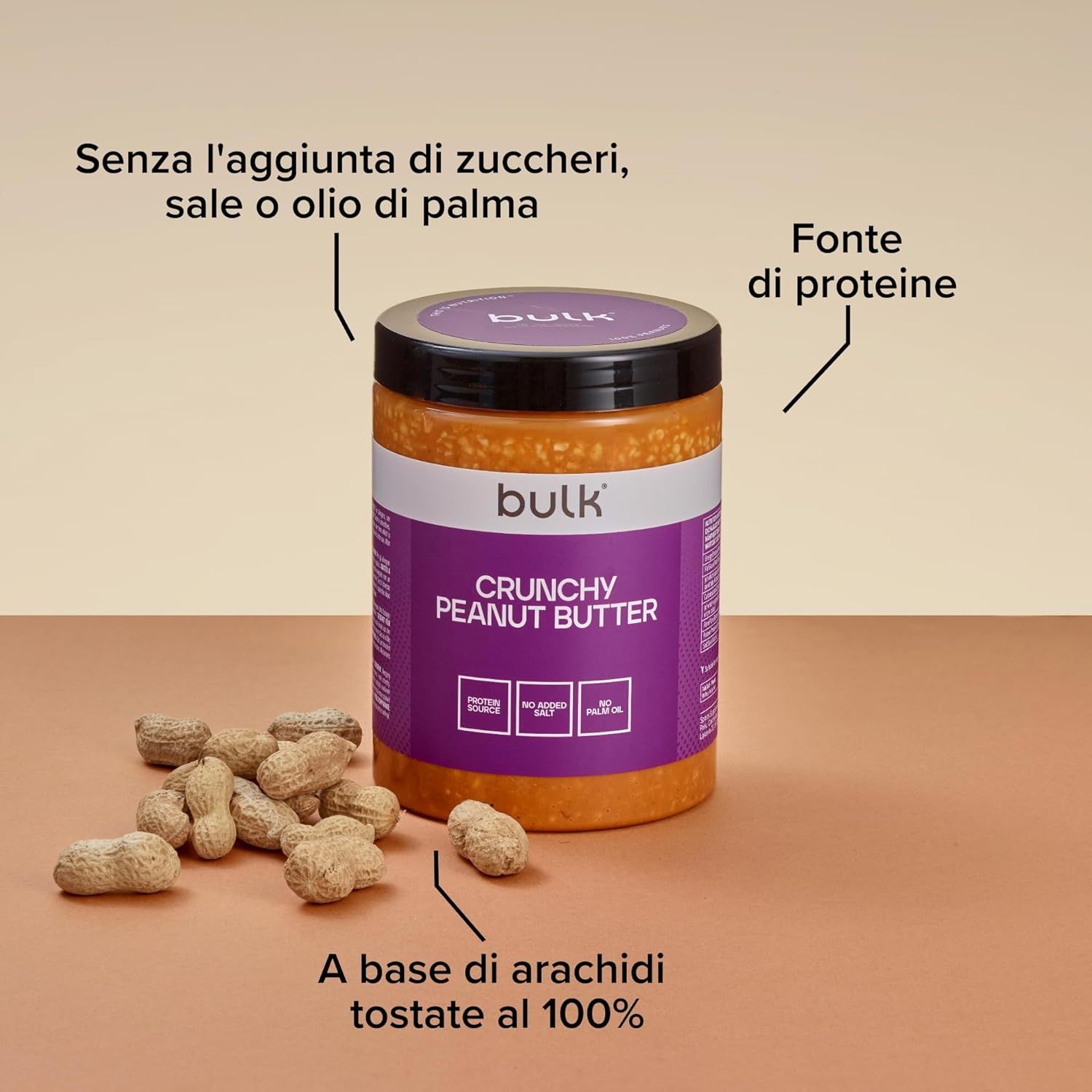 Vasetto di burro di arachidi con arachidi. Etichetta viola con "bulk", "Crunchy Peanut Butter", "Protein Source", "No Added Salt", "No Palm Oil".