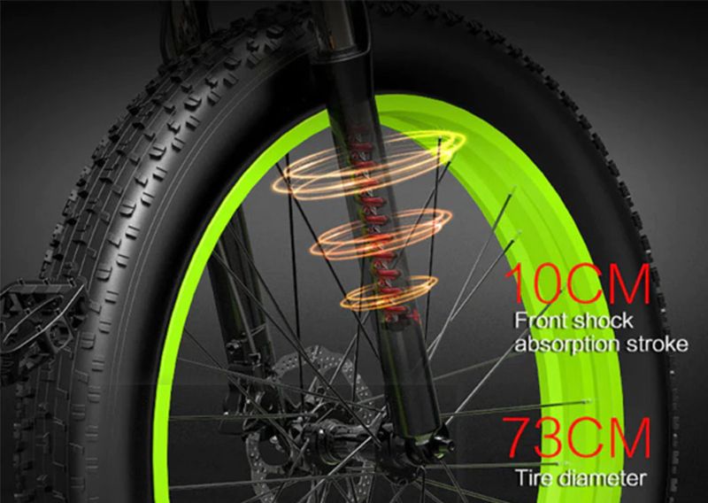 Primo piano della ruota anteriore. Cerchio verde, pneumatico nero. Scritte: 10CM, 73CM. Sospensione visibile.