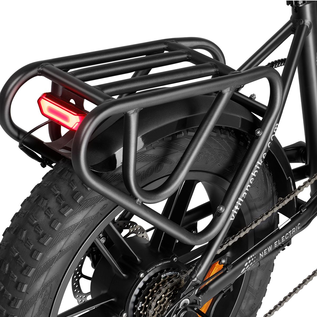 Portapacchi nero con fanale su una e-bike. Parafango e parti della ruota posteriore visibili.