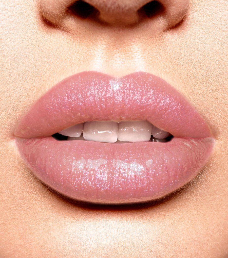 Primo piano di labbra con rossetto rosa brillante.