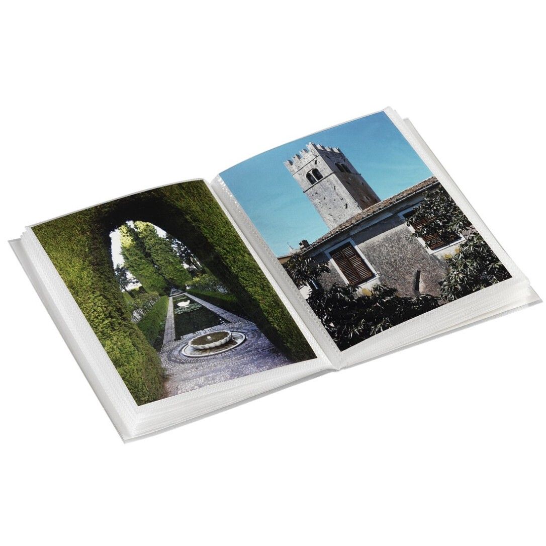 Album fotografico aperto, con foto. Pagine con immagini di giardino e torre. Copertina bianca.