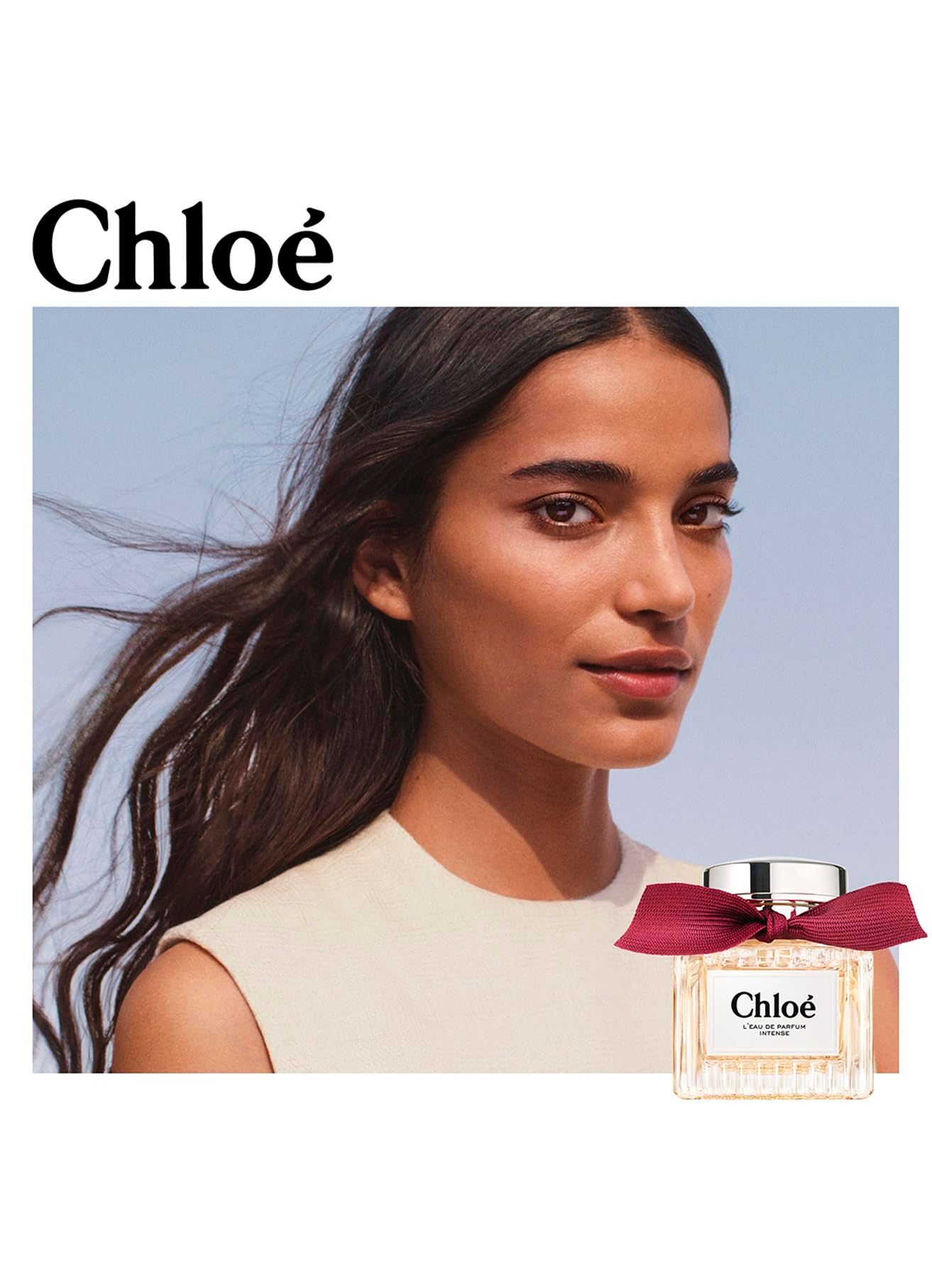 Donna con flacone. Flacone, tappo argentato, fiocco rosso. Etichetta "Chloé".