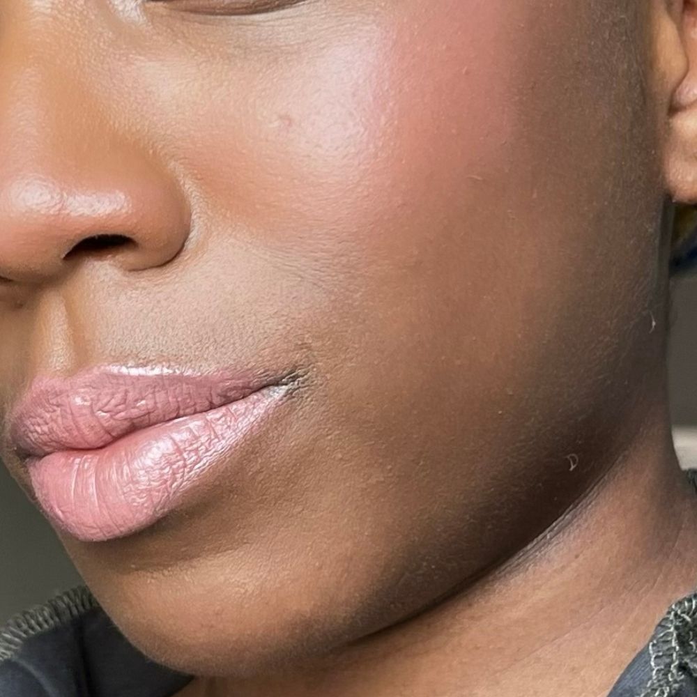 Primo piano di un viso. Labbra e guance rosa. Tonalità della pelle scura.