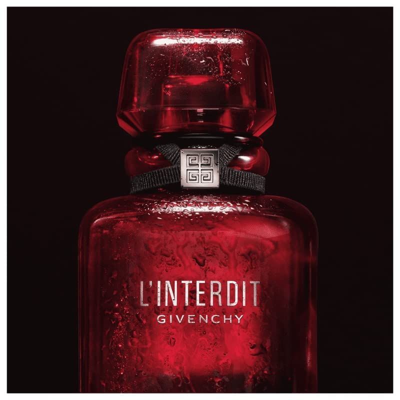 Primo piano del flacone rosso Givenchy L'Interdit Eau de Parfum Rouge. Fiocco nero, logo argento. Gocce sul vetro.