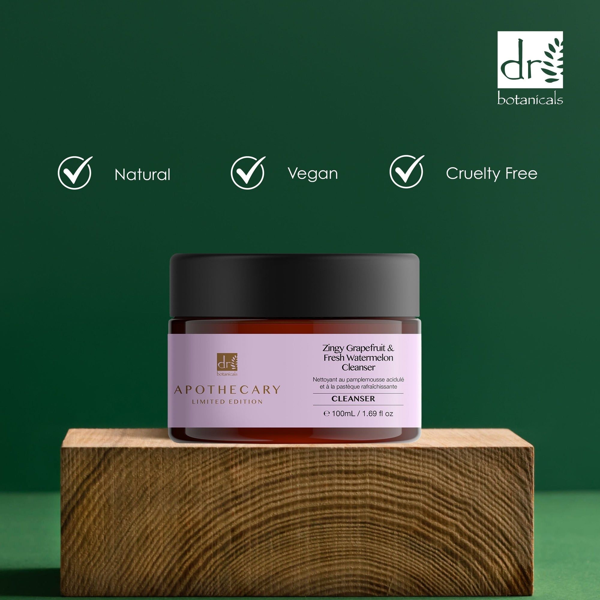 Vaso marrone con coperchio nero. Etichetta con nome del prodotto e marchio. Scritta: Natural, Vegan, Cruelty Free. Su blocco di legno.