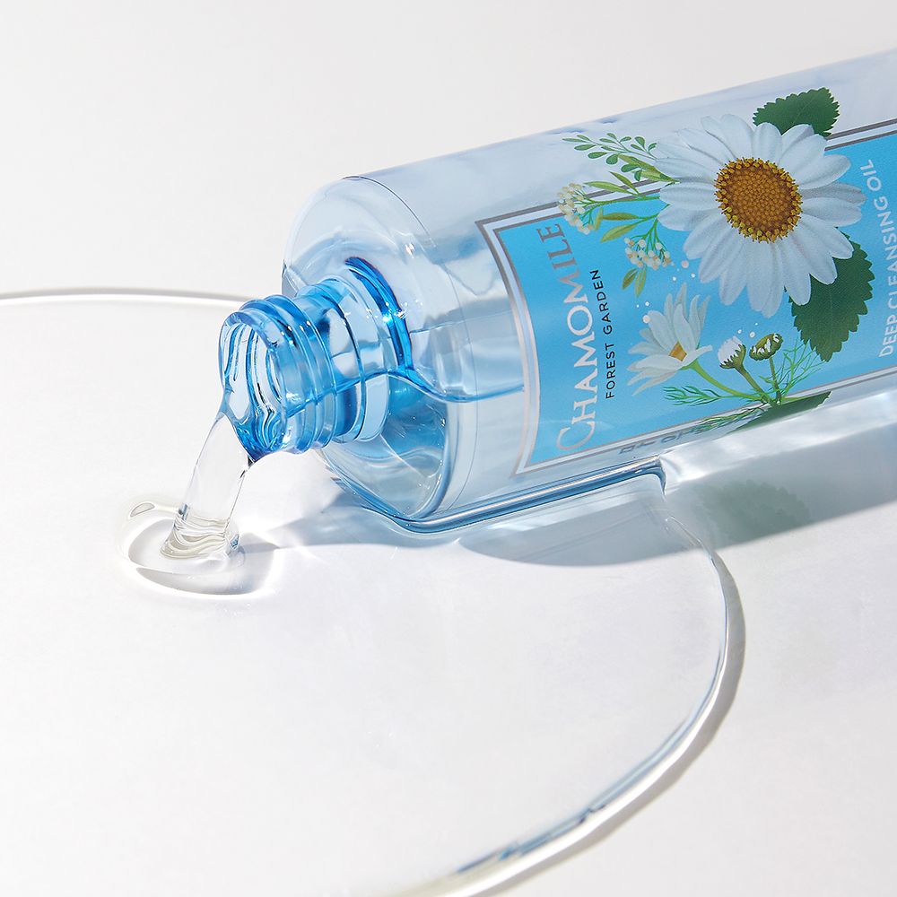 Flacone trasparente con etichetta CHAMOMILE, FOREST GARDEN, DEEP CLEANSING OIL, coricato. Liquido che fuoriesce. Marchio NATURE REPUBLIC.