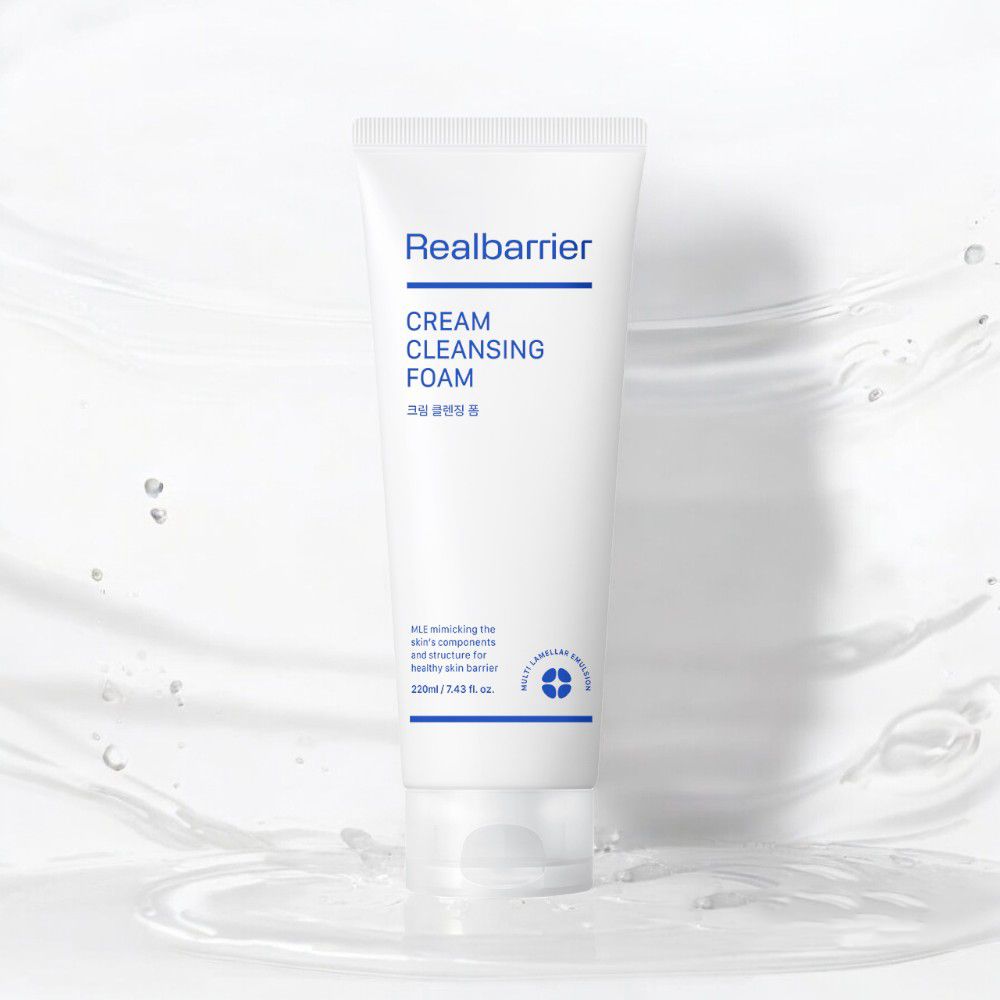 Tubo bianco "Realbarrier CREAM CLEANSING FOAM" su sfondo d'acqua. Contiene caratteri coreani e informazioni sugli ingredienti.