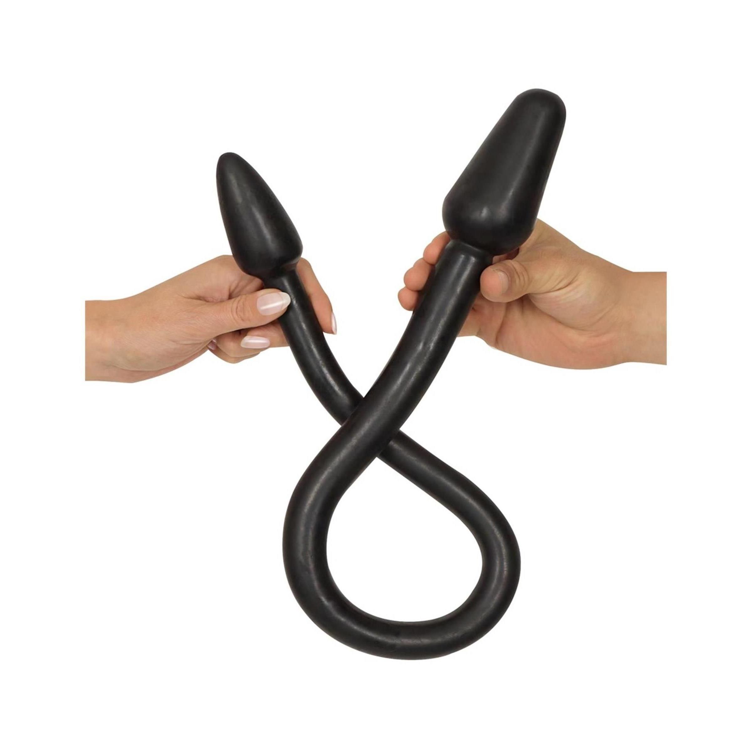 Mani che tengono un doppio dildo nero con estremità coniche.