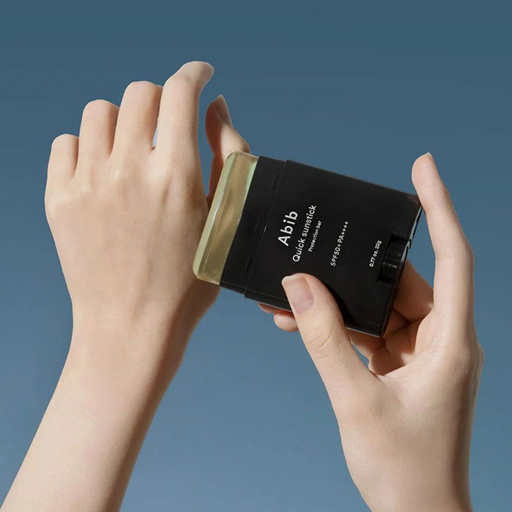 Mani che tengono ABIB Quick Sunstick Protection Bar su una mano.