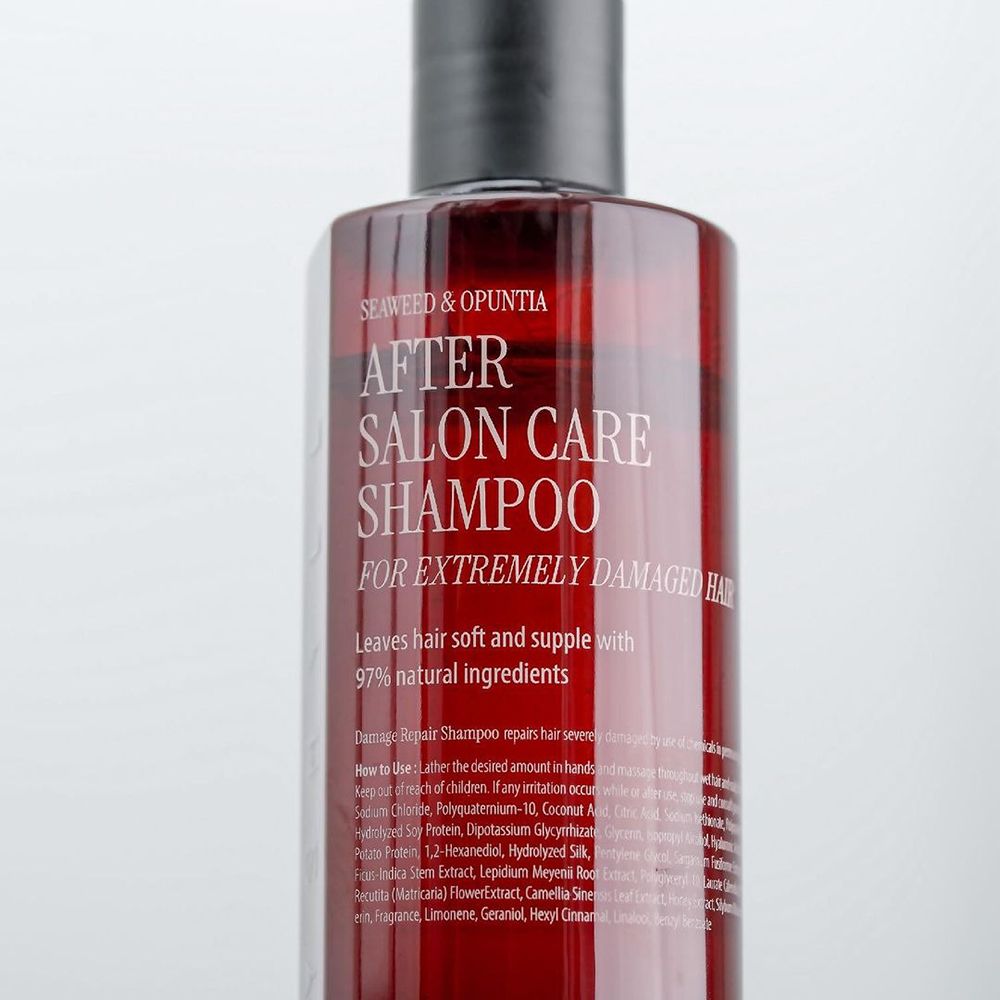 Flacone di shampoo rosso con tappo nero. Scritta: After Salon Care Shampoo per capelli estremamente danneggiati. 97% ingredienti naturali.