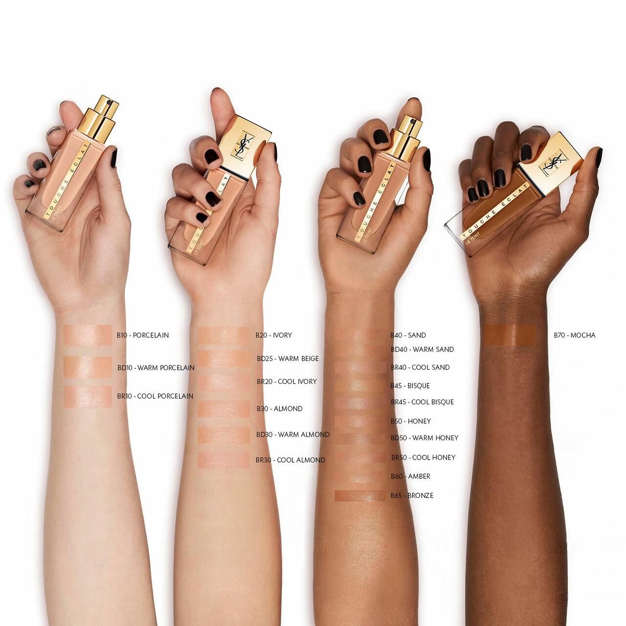 Mani che tengono flaconi Yves Saint Laurent Touche Éclat Le Teint. Campioni di colore sugli avambracci. Diverse tonalità di pelle.