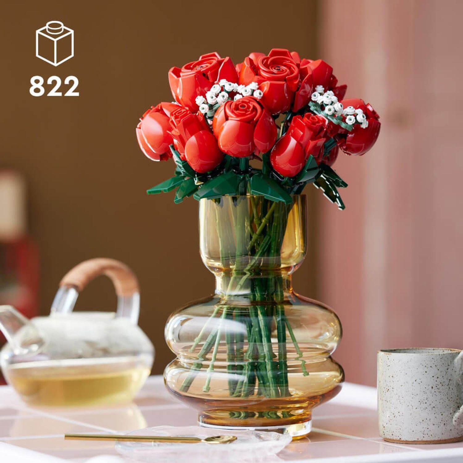 Bouquet di rose in un vaso. Sul tavolo ci sono una teiera e una tazza.