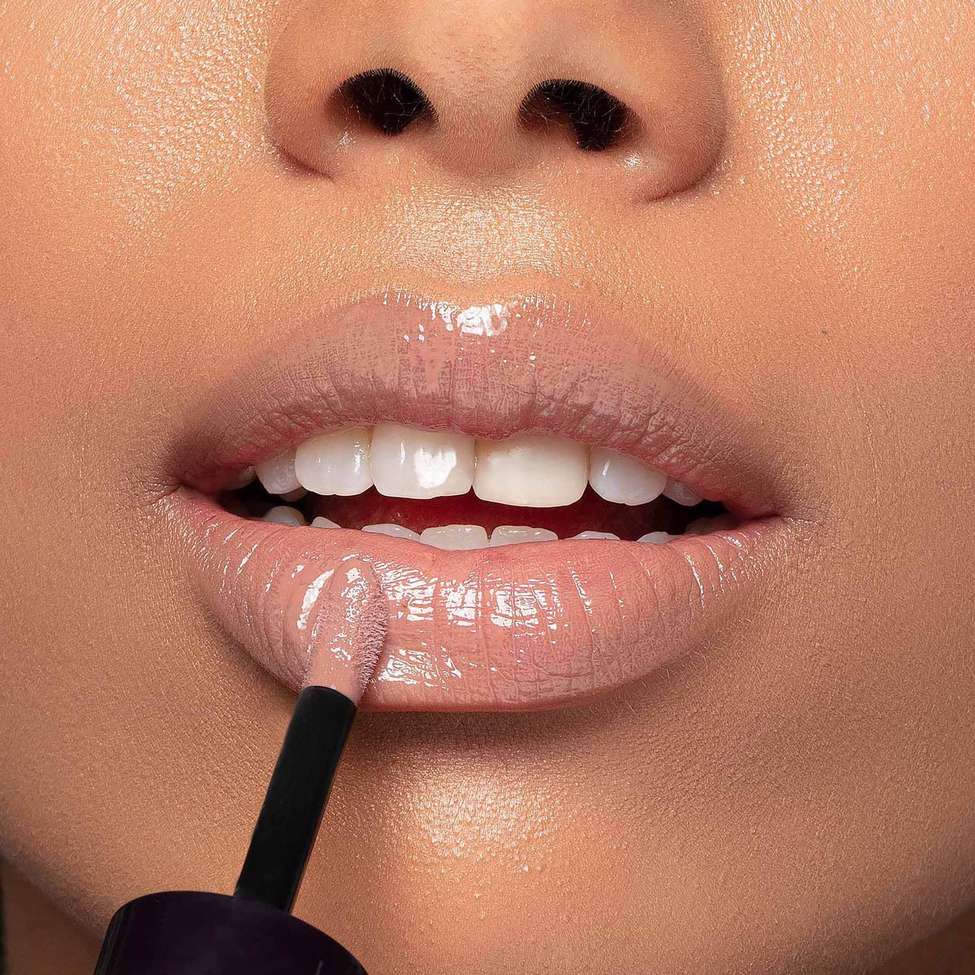 Primo piano di labbra truccate con By Terry Lip Expert Shine. Applicatore visibile. Finitura lucida.