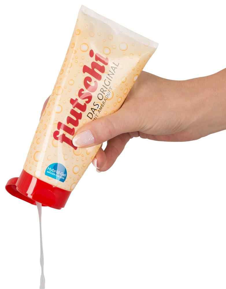 Mano che tiene un tubo. Gel che fuoriesce. Scritta: flutschi, DAS ORIGINAL, MIT AMBRADUFT.