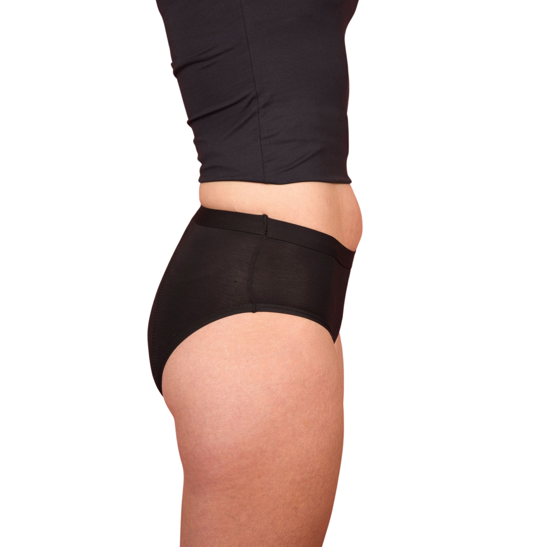 Slip nero. Vista laterale. Donna con canotta e slip neri. Sfondo bianco.