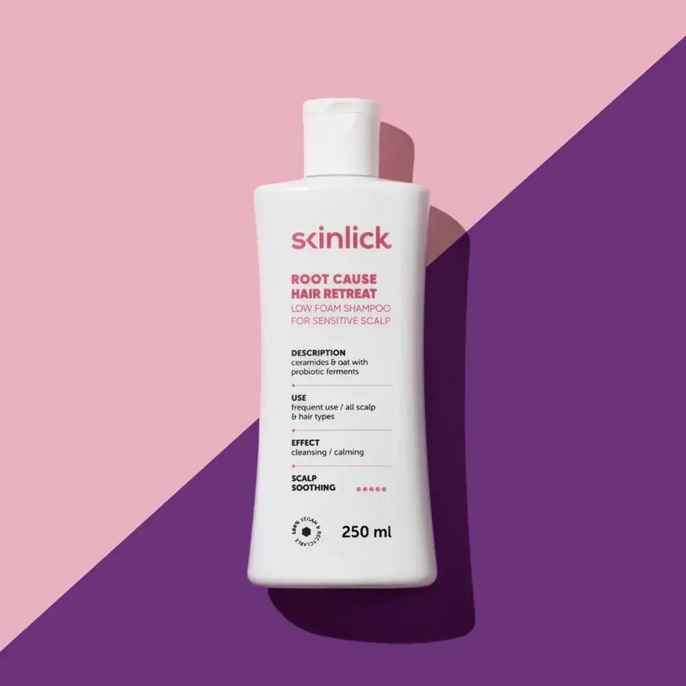 Flacone di shampoo bianco su sfondo rosa e viola. Scritta: SKINLICK, ROOT CAUSE HAIR RETREAT, 250 ml.