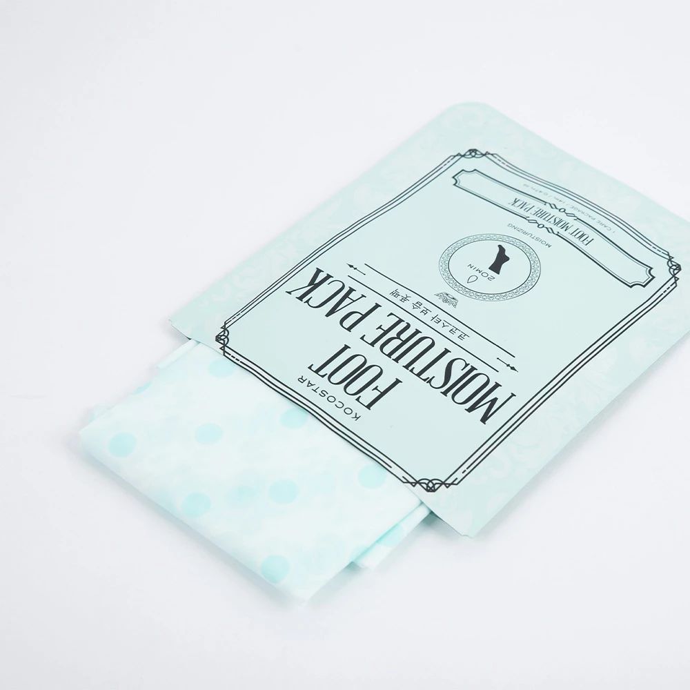 Confezione azzurra con maschera per i piedi. Testo: KOCOSTAR FOOT MOISTURE PACK. Maschera a pois che esce. Sfondo bianco.