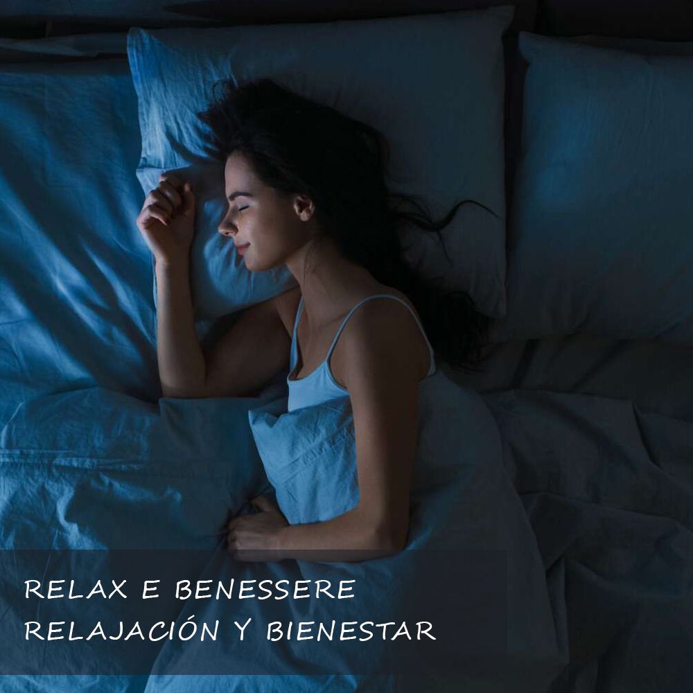 Donna che dorme in un letto blu. Testo: Relax e benessere, Relajación y bienestar.