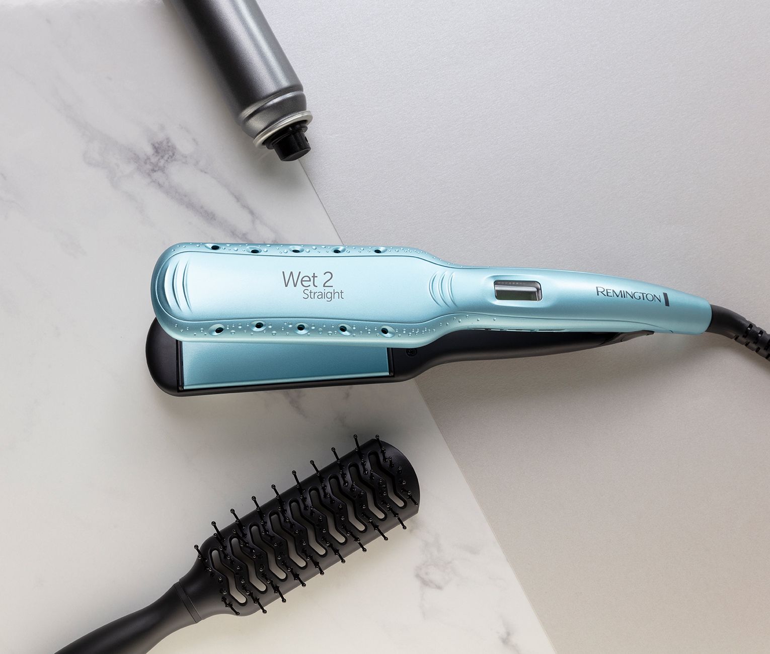 Liscia capelli azzurri con spazzola e lacca su superficie in marmo.