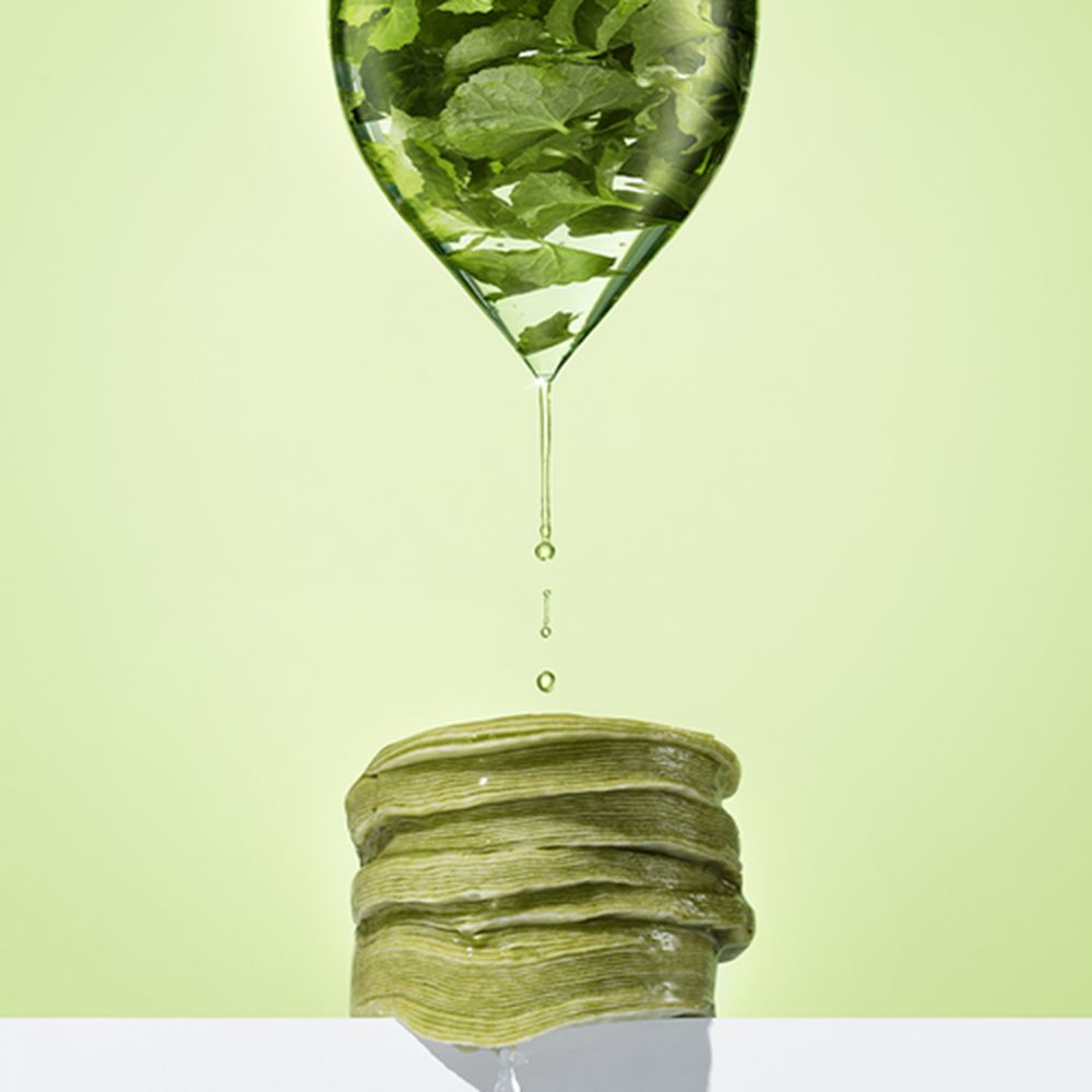 Liquido che gocciola su una pila di pad verdi. Il liquido contiene foglie verdi.