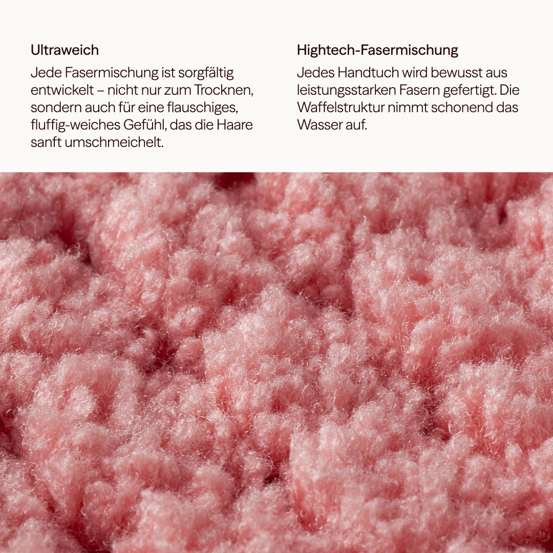Primo piano di un asciugamano in microfibra rosa con struttura a nido d'ape. Il testo descrive il materiale ultra morbido e la miscela di fibre high-tech.