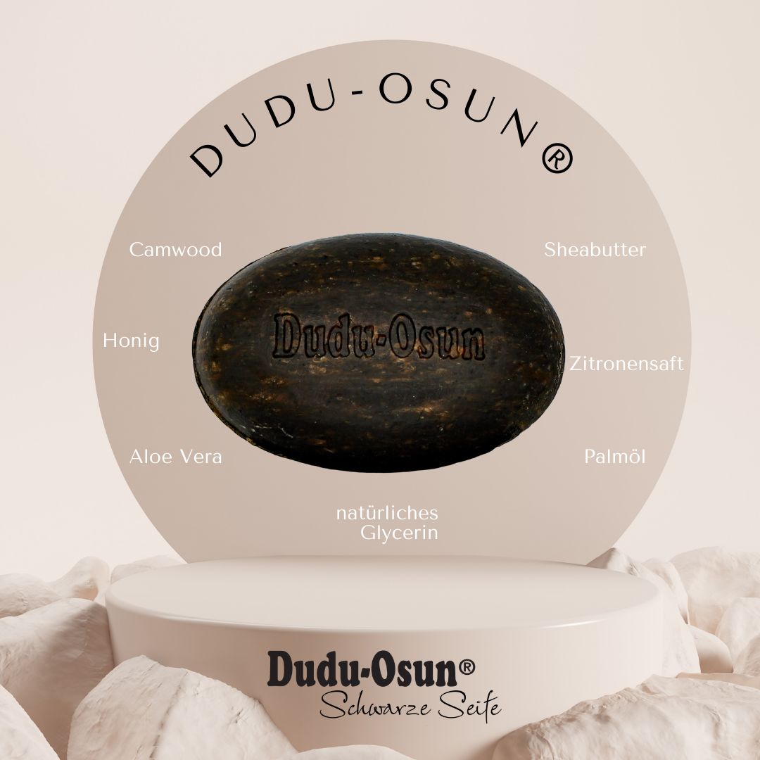 Sapone nero ovale con scritta "Dudu-Osun". Su piedistallo, con nomi ingredienti: Camwood, miele, aloe vera, burro di karité, succo di limone, olio di palma, glicerina.